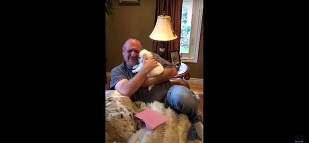 Man hugs new puppy